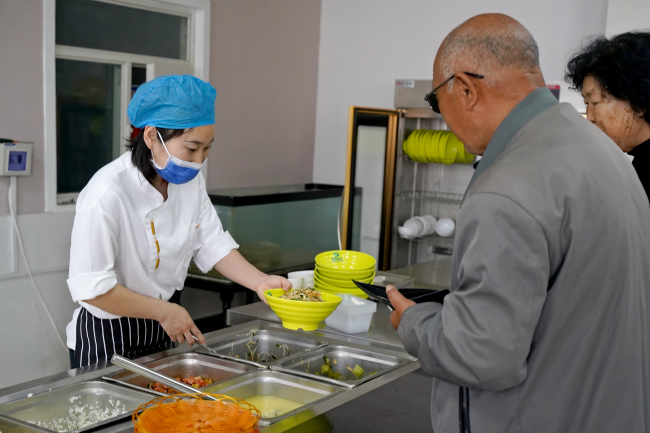 老人们在长者餐厅排队取餐。吴梦莹摄